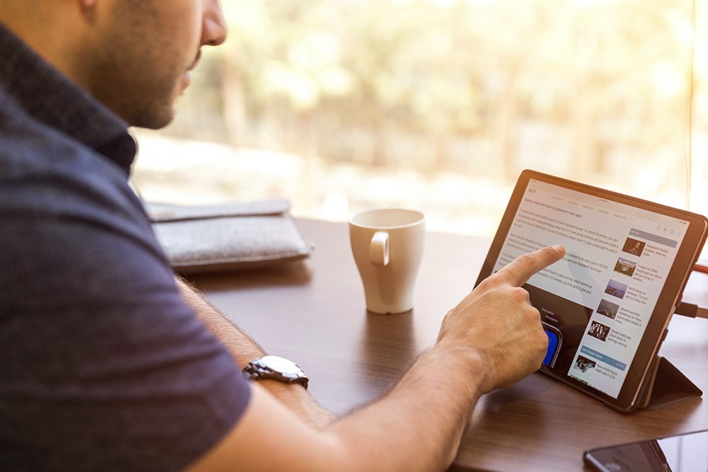 man scrolling on tablet